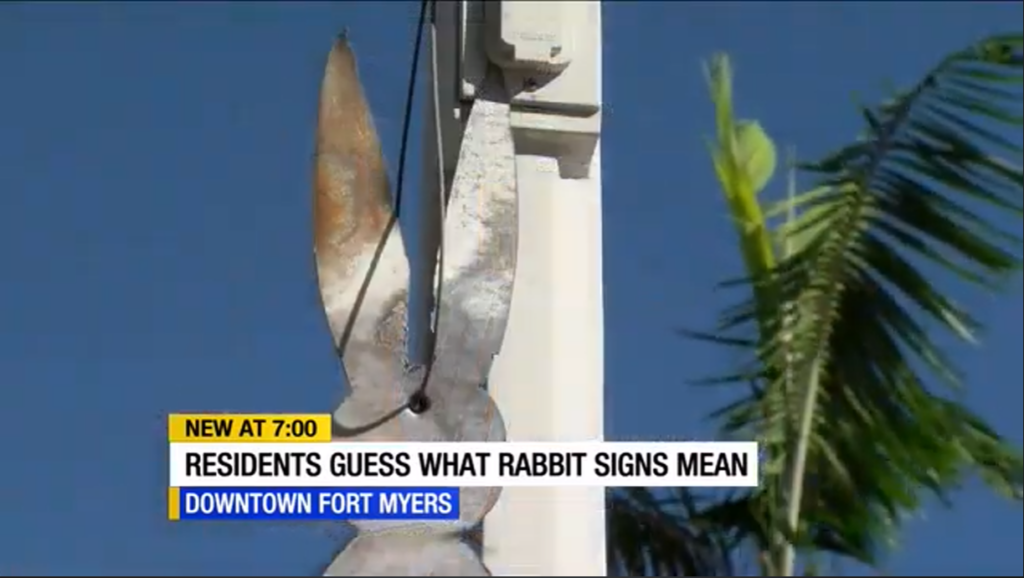 Another photo of a news report, this time with rabbit ears stuck on a random city pole.